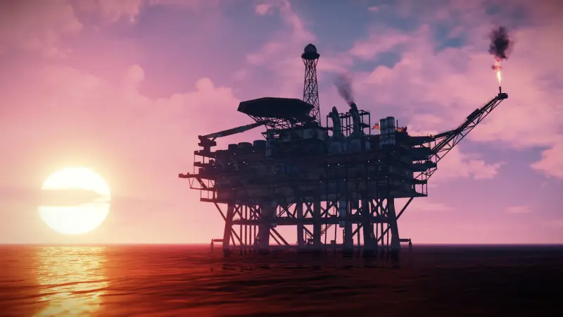 An offshore oil rig silhouetted against a pink sunset sky